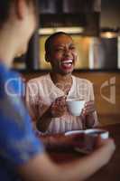 Happy friends interacting while having coffee