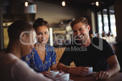 Happy friends interacting while having coffee