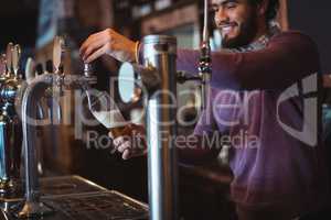 Bar tender filling beer from bar pump