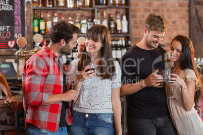 Young couples holding drinks in bar