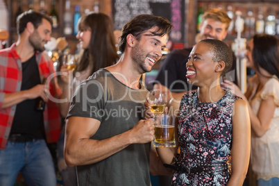 Happy young couple holding beer mugs