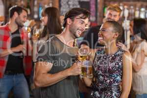 Happy young couple holding beer mugs