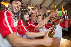 Cheerful friends looking away while holding beer bottles