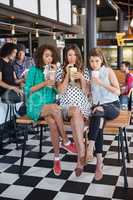 Female friends drinking smoothie at restaurant