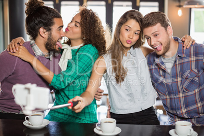 Friends taking selfie while enjoying in cafe