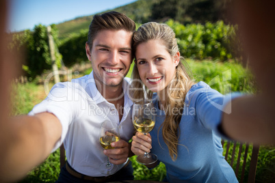 Portrait of happy couple holding wineglasses at vineyard
