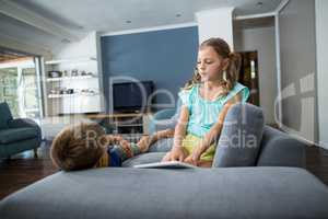 Siblings interacting with each other in living room