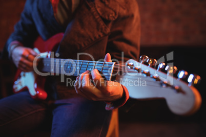 Mid-section of man playing guitar