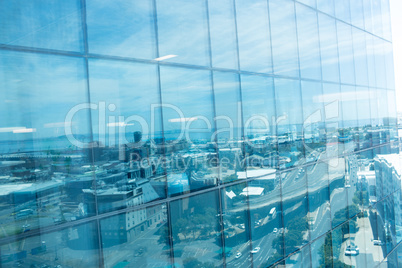 Office building exterior with reflection of city against sky