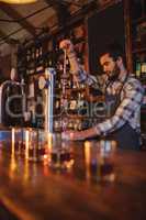 Waiter using beer tap at counter