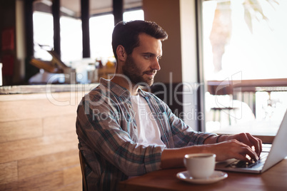 Man using laptop while having coffee