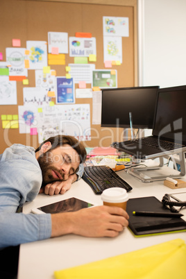 Tired businessman napping in creative office
