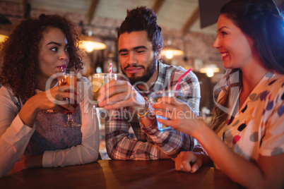 Young friends interacting with each other having drinks