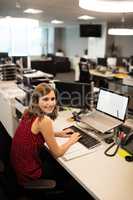 Smiling businesswoman using computer in office
