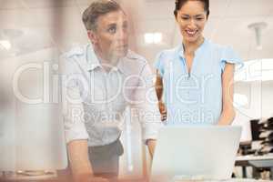 Businessman discussing with smiling female colleague at office