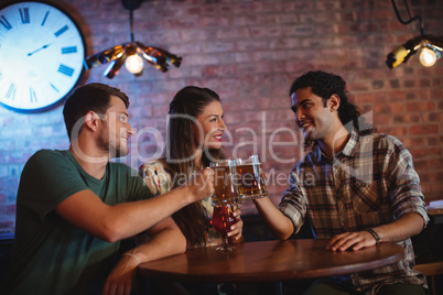 Young friends toasting beer mugs