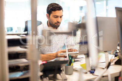 Businessman using mobile phone at desk in office