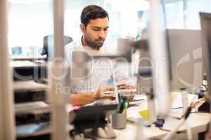 Businessman using mobile phone at desk in office