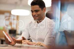 Smiling businessman discussing with female colleague on digital tablet
