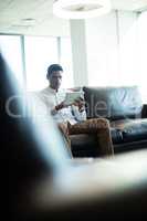 Businessman using digital tablet while sitting on sofa