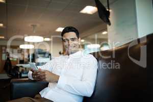 Portrait of businessman using mobile phone while sitting at office