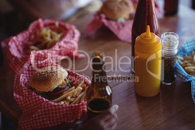 Fast food and beer bottle on table