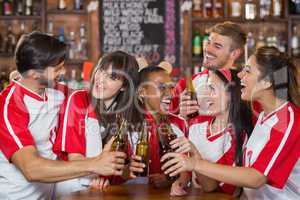 Happy friends holding beer bottles