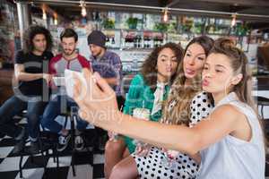 Female friends taking selfie at restaurant
