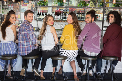 Friends sitting on stools at restaurant