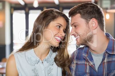 Young friends looking at each other in restaurant