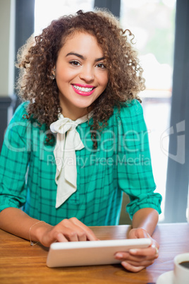 Smiling young woman holding digital tablet