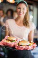 Waitress serving burgers in restaurant