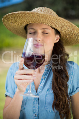 Young woman smelling red wine in glass