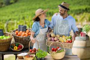 Happy couple standing by fresh fruits and vegetables