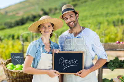 Portrait of happy couple holding chalkboard with text