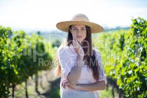 Beautiful young woman standing at vineyard