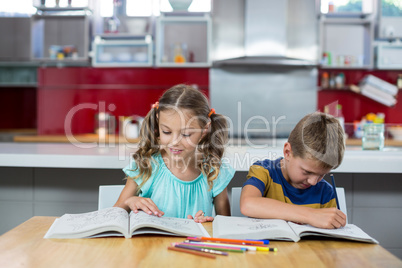 Siblings doing homework in kitchen