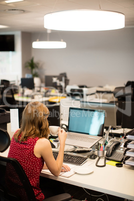 Female business executive drinking coffee in office