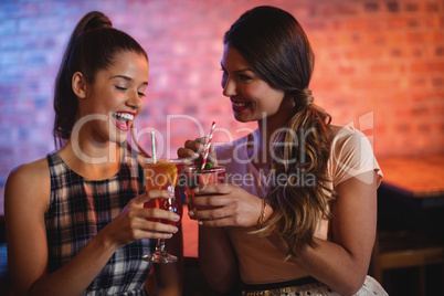 Two young women having cocktail drinks