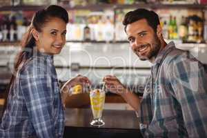 Portrait of happy couple having milkshake at counter