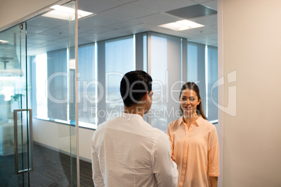 Businessman and businesswoman talking in office