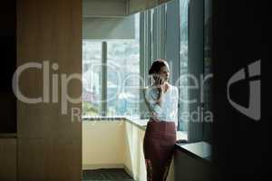 Businesswoman talking on phone in office