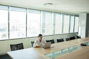 Businesswoman using laptop in conference room