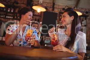 Two young women having cocktail drinks