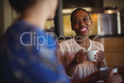 Happy friends interacting while having coffee