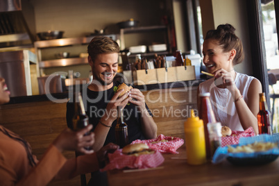 Happy friends interacting while having meal and beer