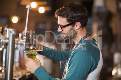 Side view of bartender making drinks while wearing eyeglasses