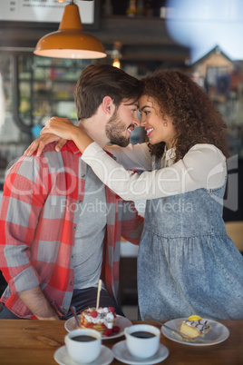 Happy young couple embracing in pub