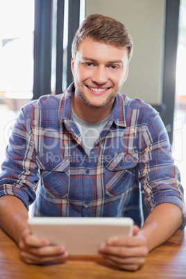 Smiling young man using tablet computer