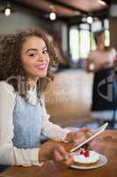 Portrait of young woman using tablet pc in restaurant